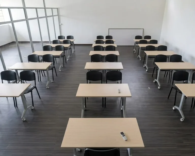 Salón de clase escolar moderno con filas de escritorios y sillas de madera vacías, representando mobiliario educativo en Colombia listo para los estudiantes.